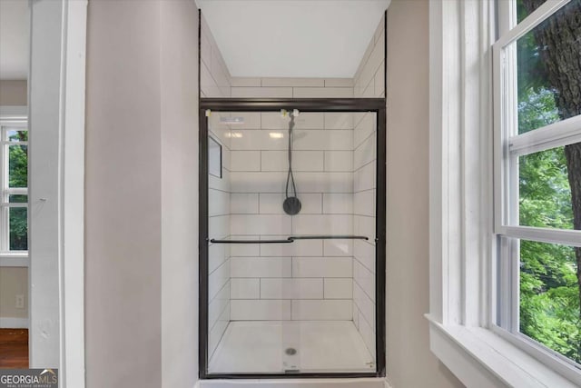 bathroom with walk in shower and a healthy amount of sunlight