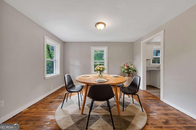 dining area featuring dark wood-type flooring and a wealth of natural light