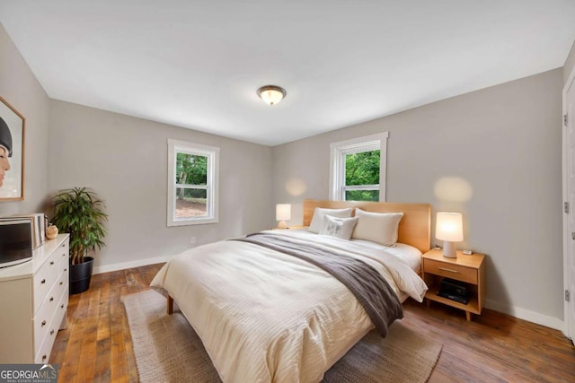 bedroom featuring dark hardwood / wood-style floors and multiple windows