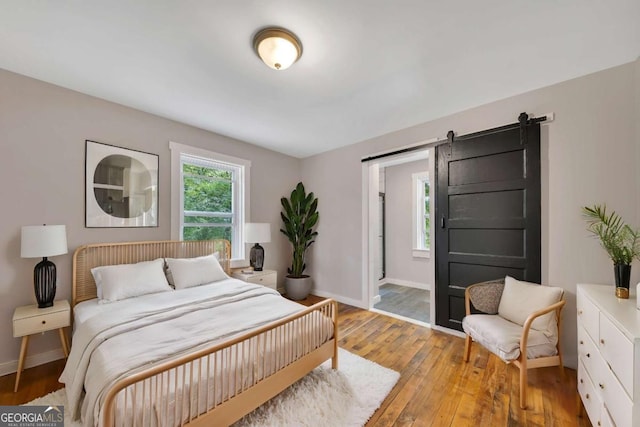 bedroom featuring a barn door and light wood-type flooring