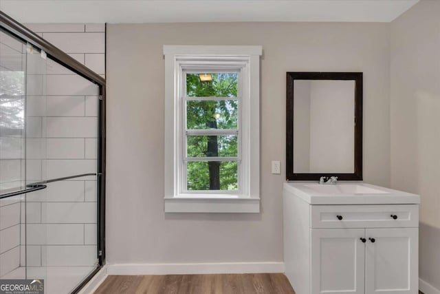 bathroom featuring walk in shower, vanity, and hardwood / wood-style flooring