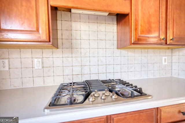 kitchen with stainless steel gas stovetop and backsplash