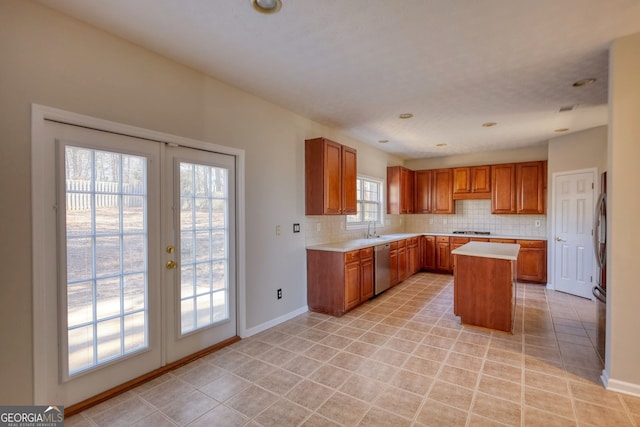 kitchen featuring tasteful backsplash, a center island, stainless steel dishwasher, light tile patterned flooring, and french doors