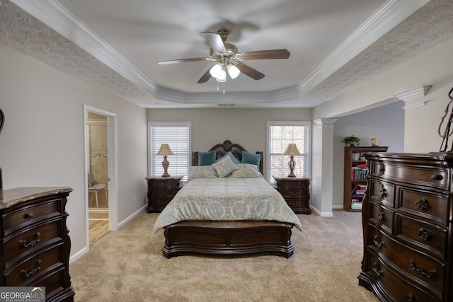 carpeted bedroom featuring ceiling fan, ensuite bathroom, a raised ceiling, and multiple windows