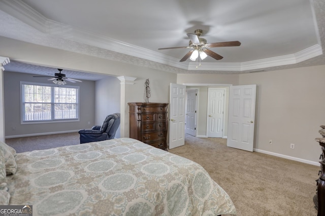 carpeted bedroom featuring ceiling fan, a raised ceiling, crown molding, and ornate columns