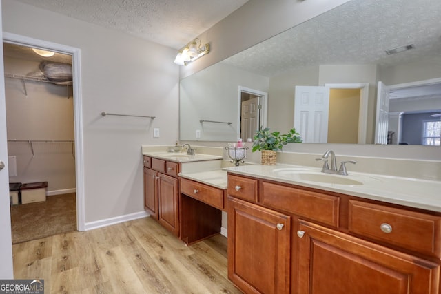 bathroom featuring wood-type flooring, a textured ceiling, and vanity