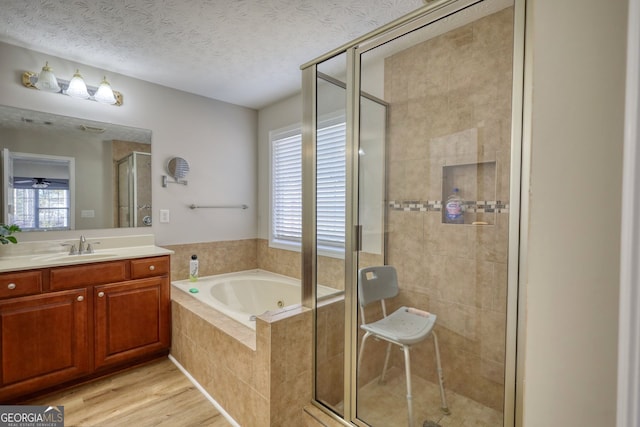 bathroom with plenty of natural light, a textured ceiling, hardwood / wood-style floors, and shower with separate bathtub