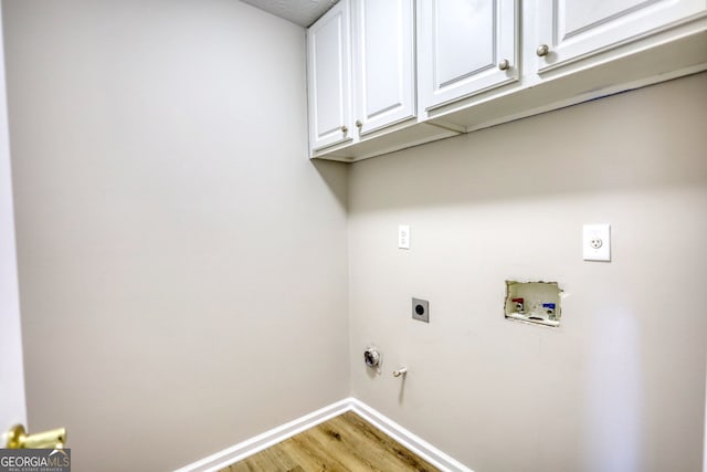 laundry room featuring light hardwood / wood-style floors, hookup for an electric dryer, washer hookup, cabinets, and gas dryer hookup