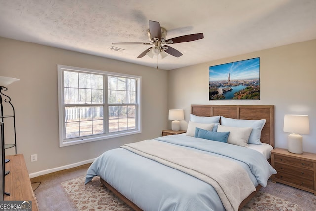 carpeted bedroom with a textured ceiling and ceiling fan