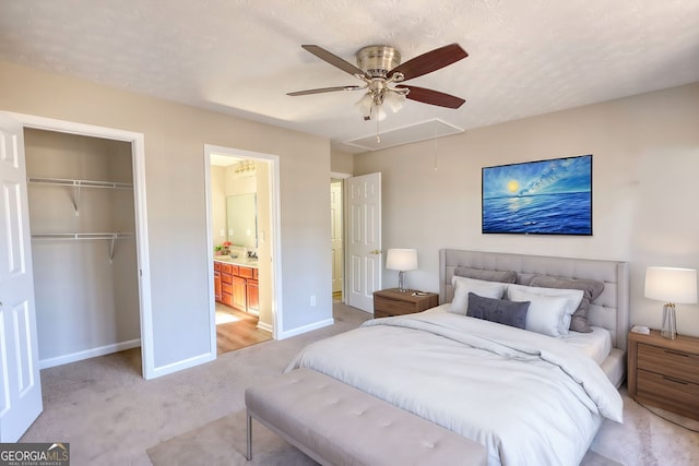 bedroom featuring ceiling fan, light colored carpet, a closet, and a textured ceiling