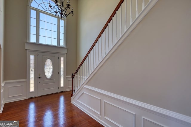 entrance foyer featuring dark hardwood / wood-style floors, an inviting chandelier, and plenty of natural light