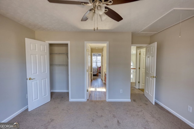 unfurnished bedroom with ceiling fan, a closet, and light carpet