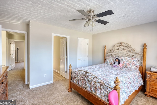 bedroom featuring ceiling fan, a textured ceiling, and light carpet