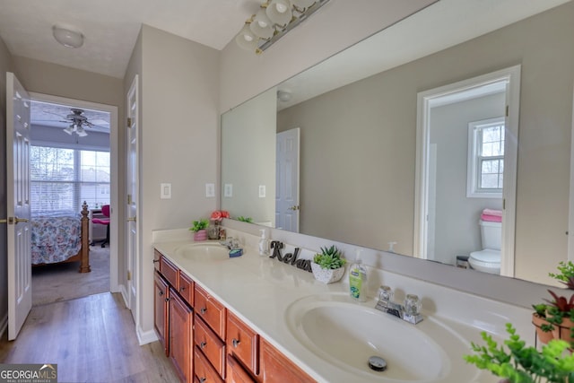 bathroom with toilet, vanity, ceiling fan, and hardwood / wood-style floors