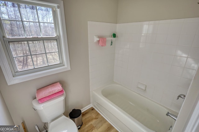 bathroom with toilet, a bathtub, and hardwood / wood-style floors