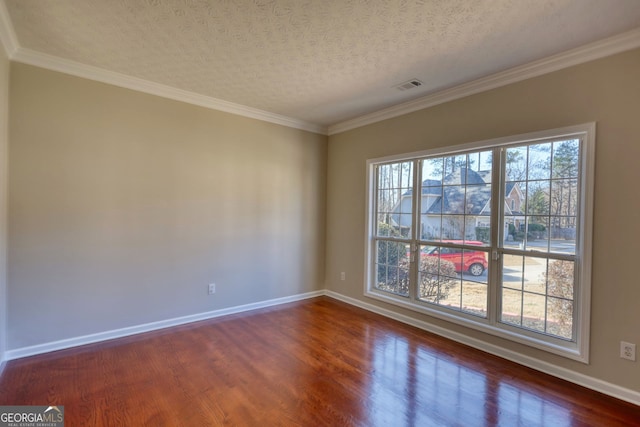 unfurnished room featuring a textured ceiling, dark wood-type flooring, and ornamental molding