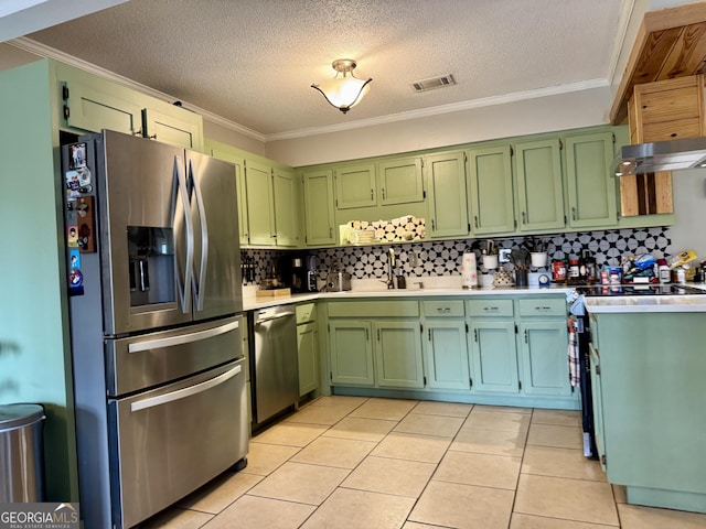 kitchen with a textured ceiling, appliances with stainless steel finishes, sink, light tile patterned flooring, and crown molding