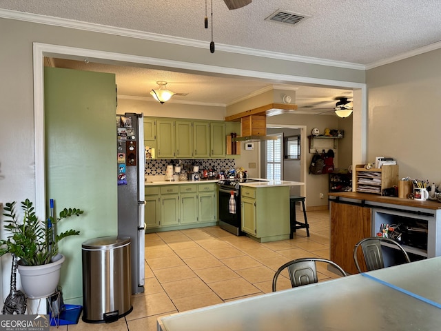 kitchen with ceiling fan, green cabinetry, stainless steel appliances, and a textured ceiling