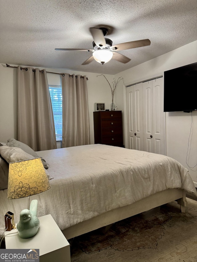 bedroom featuring a textured ceiling, ceiling fan, and a closet