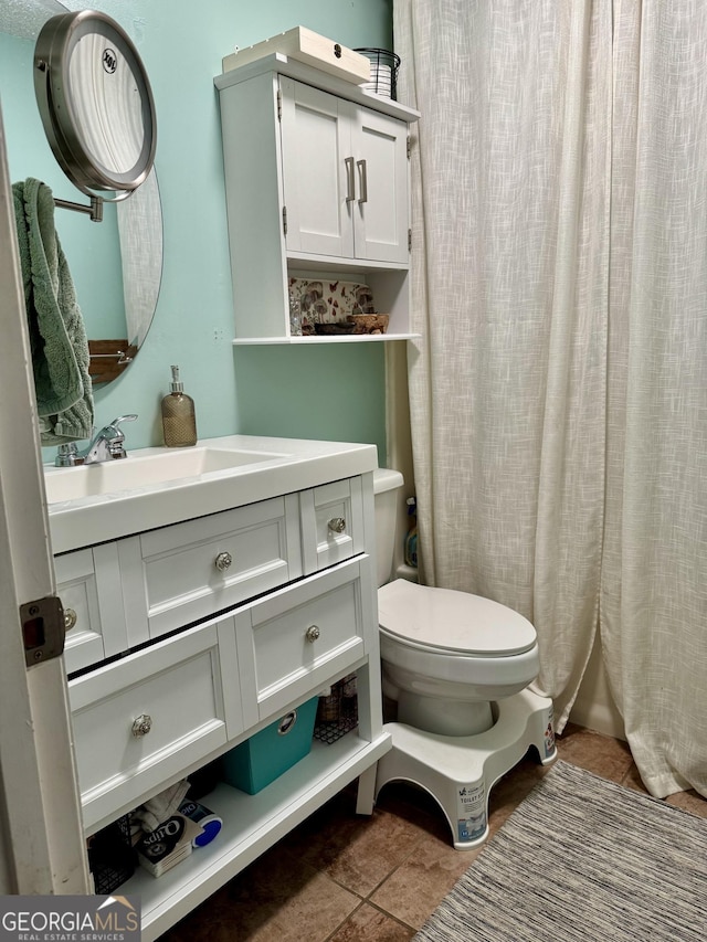 bathroom featuring tile patterned floors, toilet, and vanity