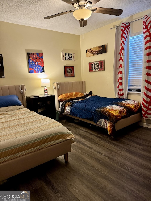 bedroom with ceiling fan, dark wood-type flooring, and a textured ceiling