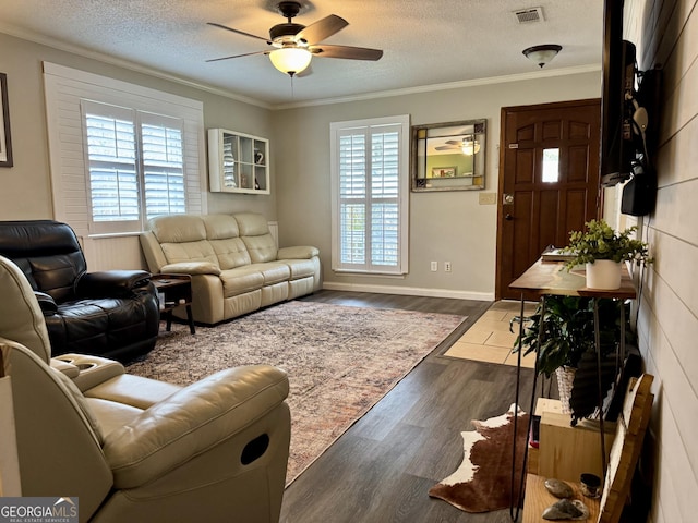 living room with a textured ceiling, ceiling fan, dark hardwood / wood-style flooring, and crown molding