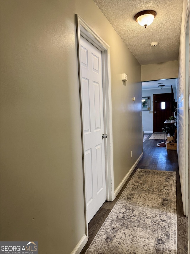 hallway with dark wood-type flooring and a textured ceiling