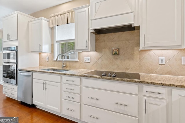 kitchen with sink, white cabinets, and custom range hood