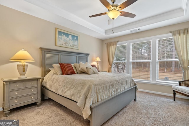 carpeted bedroom featuring ceiling fan, a tray ceiling, and ornamental molding