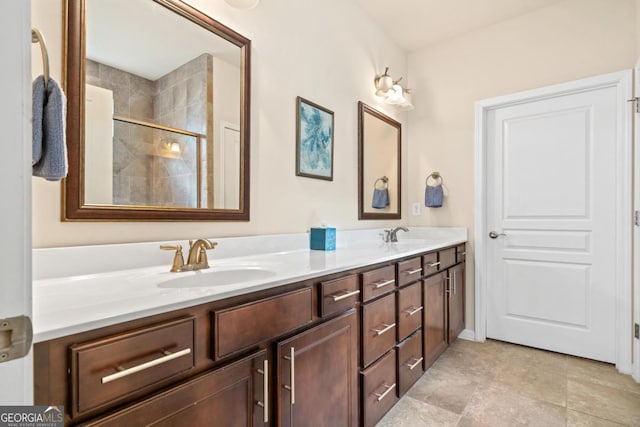 bathroom featuring a shower with shower door and vanity