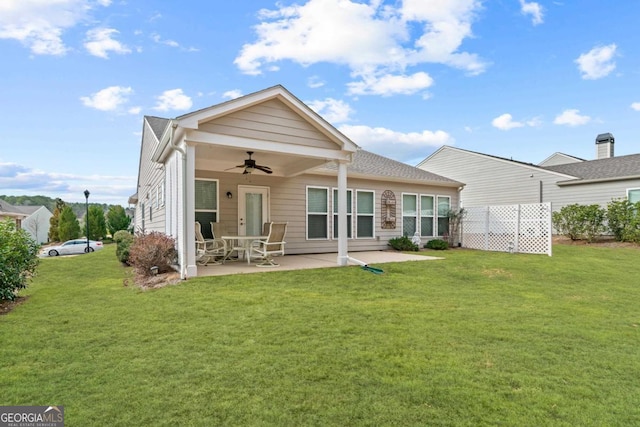 back of property with ceiling fan, a lawn, and a patio