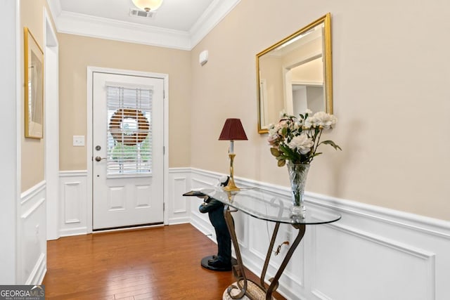 foyer with wood-type flooring and crown molding