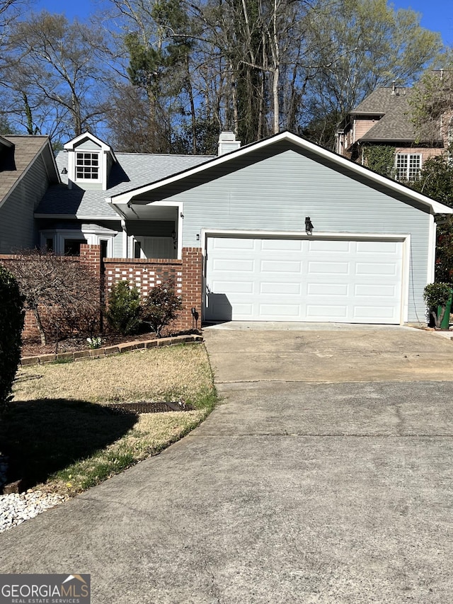 view of front of property featuring a garage, brick siding, driveway, and a shingled roof