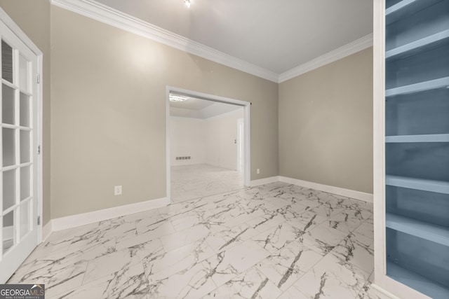 spare room featuring built in shelves and crown molding