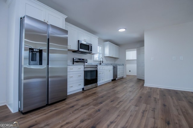 kitchen featuring sink, white cabinetry, appliances with stainless steel finishes, and dark hardwood / wood-style flooring