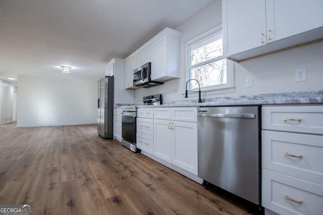 kitchen with sink, light stone countertops, appliances with stainless steel finishes, dark wood-type flooring, and white cabinets