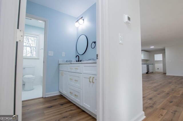 bathroom featuring toilet, hardwood / wood-style flooring, and vanity