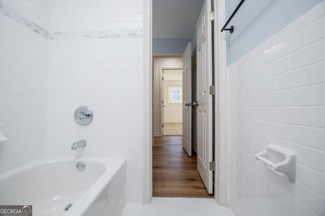 bathroom with tile walls and shower / washtub combination