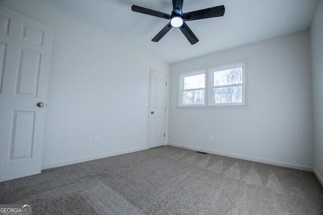 carpeted spare room with ceiling fan