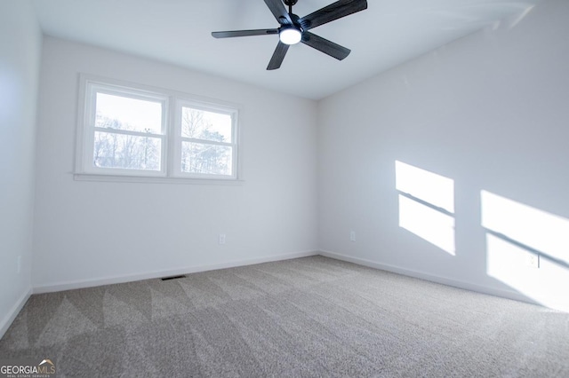 carpeted spare room featuring ceiling fan