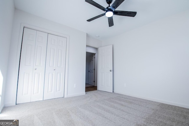 unfurnished bedroom with ceiling fan, light colored carpet, and a closet