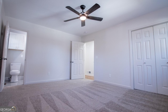 unfurnished bedroom with ceiling fan, light colored carpet, a closet, and connected bathroom