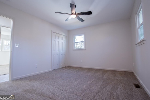 unfurnished bedroom featuring ceiling fan, carpet, and a closet