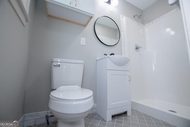 bathroom with toilet, walk in shower, and vanity