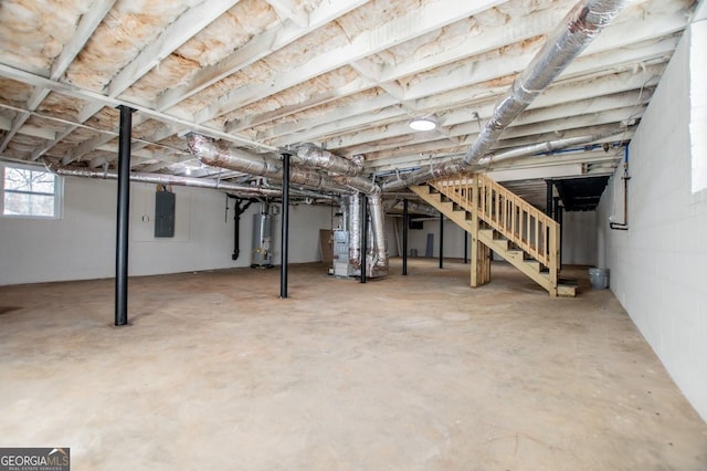 basement with electric panel, heating unit, and water heater