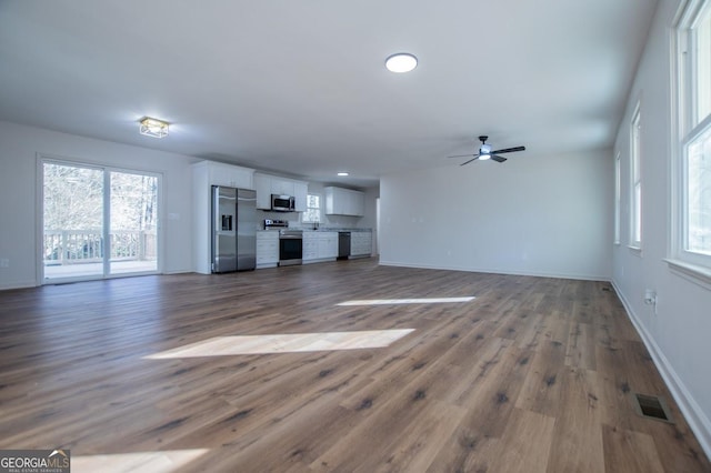 unfurnished living room featuring ceiling fan and wood-type flooring