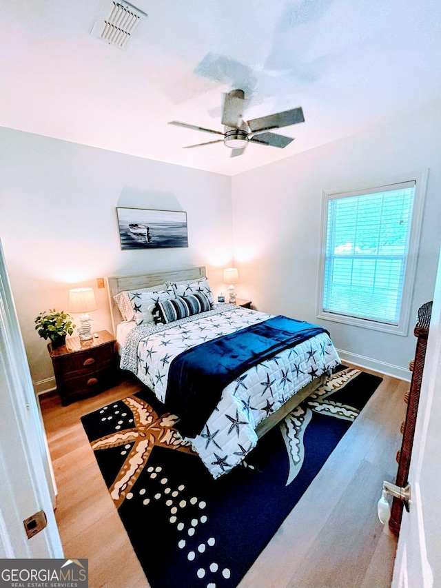 bedroom with hardwood / wood-style floors and ceiling fan