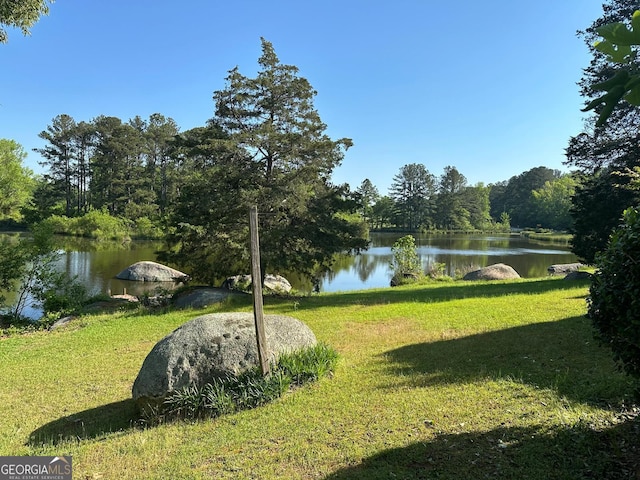 view of home's community with a yard and a water view