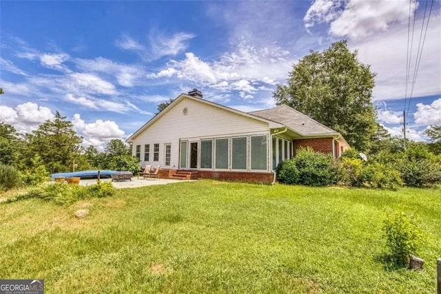 back of house featuring a yard and a patio