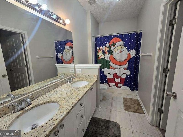 bathroom with toilet, tile patterned flooring, a textured ceiling, a shower with curtain, and vanity